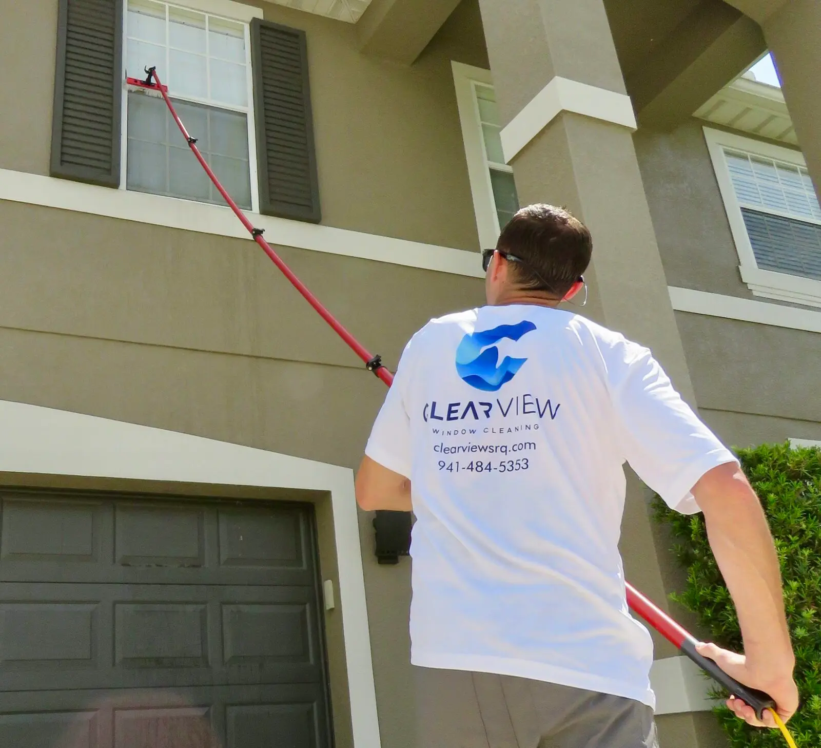 Clearview technician working a tall Sarasota property with a water-fed pole