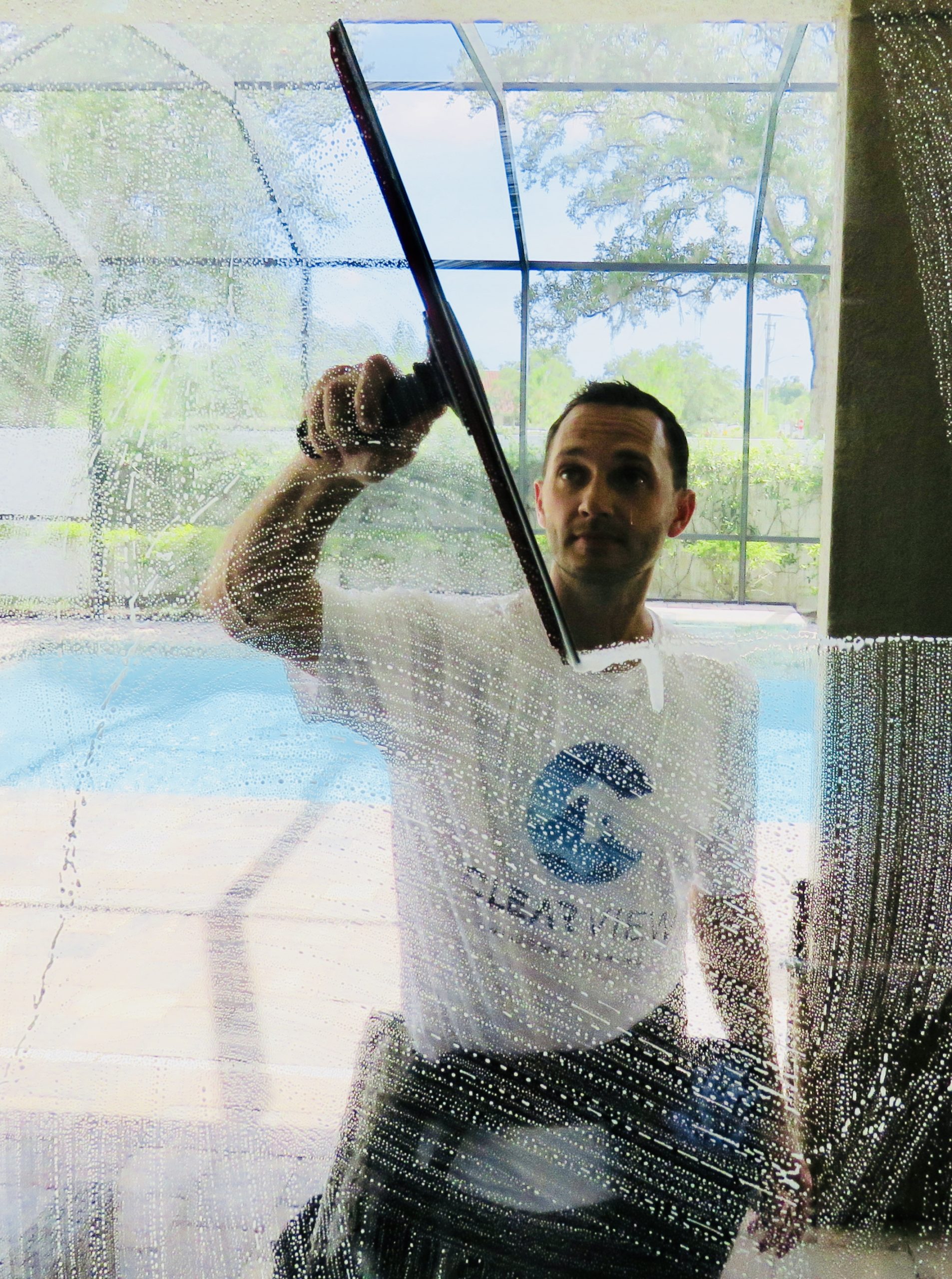 Justin Vangen, owner of Clearview Window Cleaning, squeegeeing a window in Sarasota